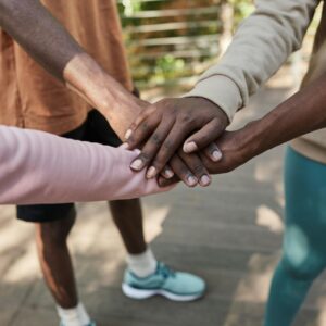 group of people standing with their hands in a huddle